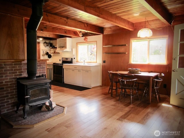 845 Schmid Rd, Grayland, WA 98547 - kitchen with stainless steel range with electric stovetop, a wood stove, open shelves, wooden ceiling, and light wood-style flooring