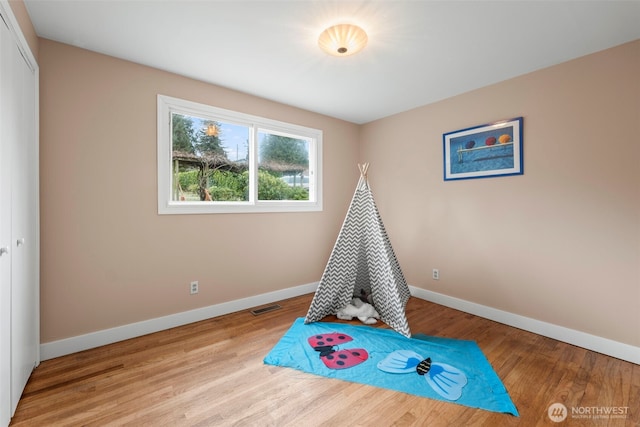 playroom featuring light wood-style floors, visible vents, and baseboards