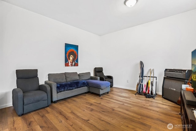 living area with baseboards and wood finished floors