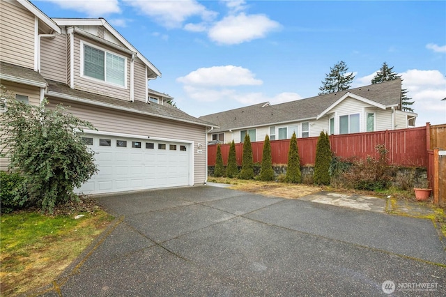 view of front of house featuring aphalt driveway and fence