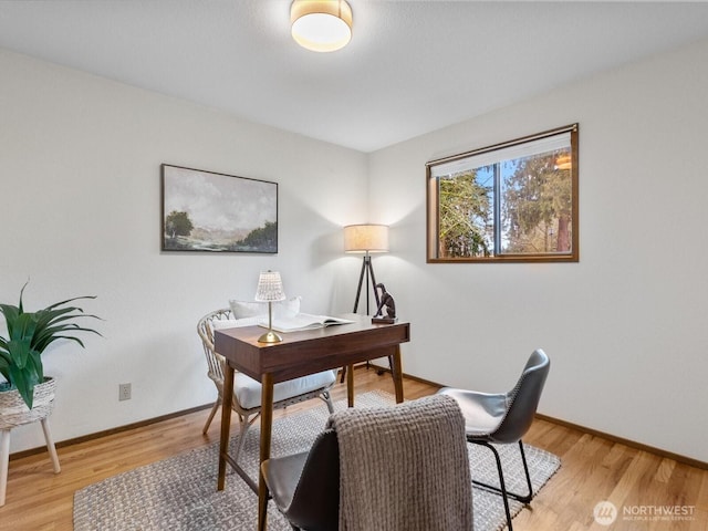 home office with light wood-style flooring and baseboards