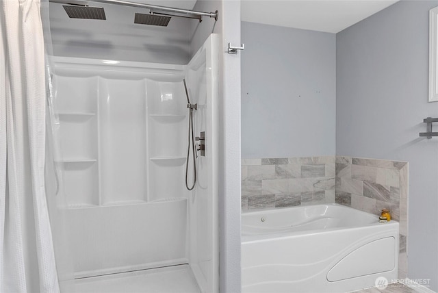 bathroom with a stall shower and a bath