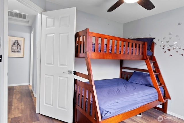 bedroom with dark wood-style floors, baseboards, visible vents, and ceiling fan