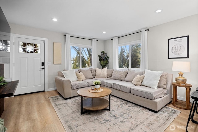 living room with light wood-style floors and recessed lighting