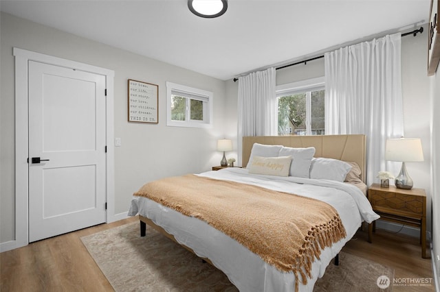 bedroom with light wood-style flooring and baseboards