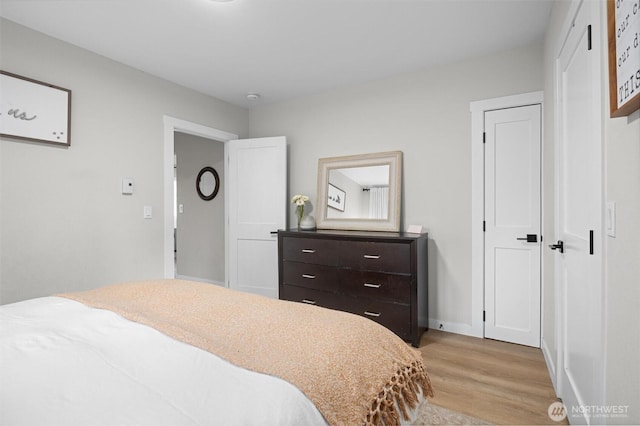 bedroom featuring baseboards and light wood-style floors