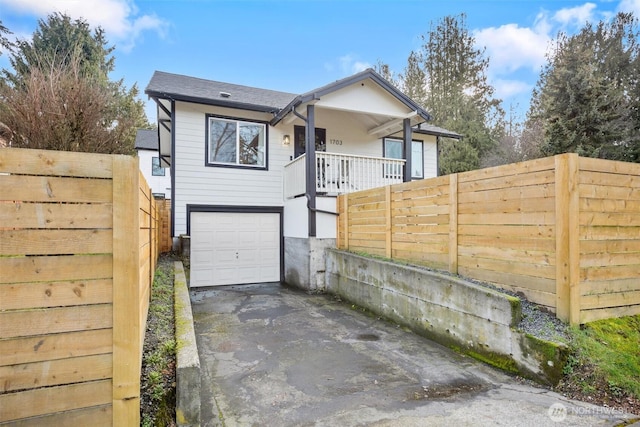 view of front of property with a garage, fence, and aphalt driveway