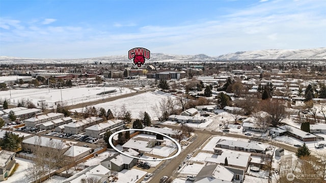 snowy aerial view featuring a residential view and a mountain view