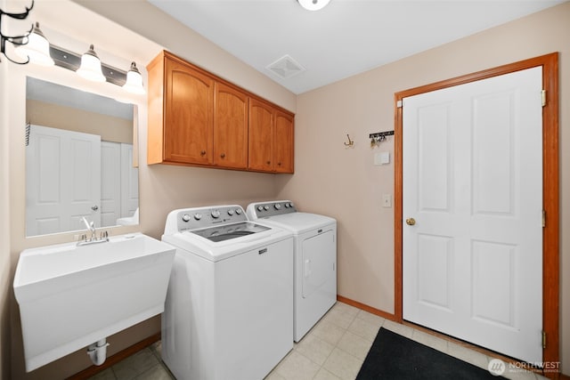 laundry area with washer and clothes dryer, a sink, cabinet space, and baseboards