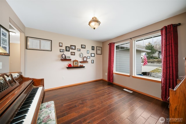 interior space featuring dark wood-style floors, baseboards, and visible vents