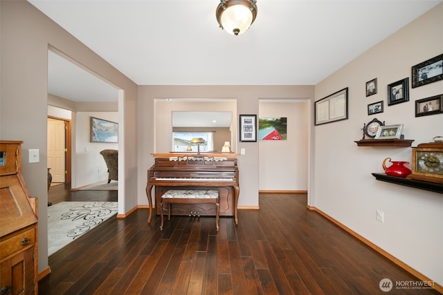 living area featuring baseboards and dark wood-style flooring