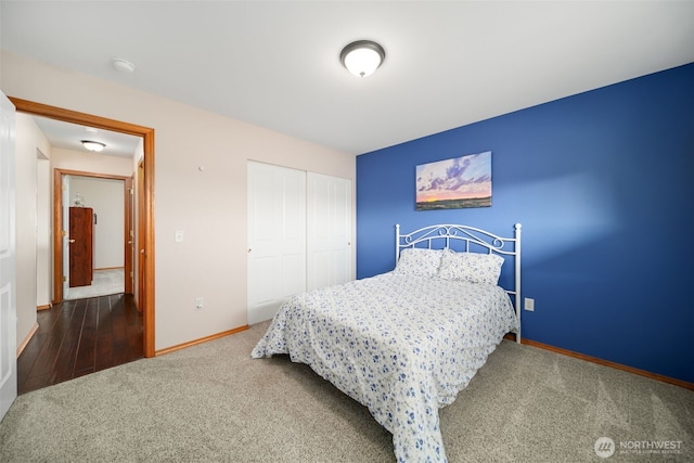 carpeted bedroom with a closet and baseboards