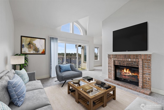 living area with high vaulted ceiling, a brick fireplace, light colored carpet, and baseboards