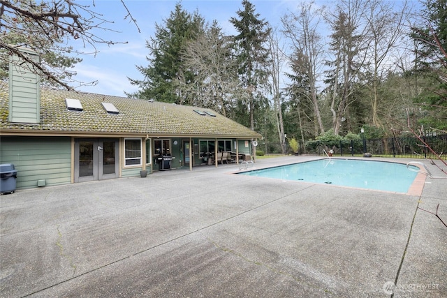 view of pool featuring a fenced in pool, french doors, a patio, area for grilling, and fence