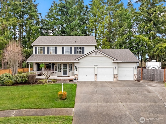 view of front of property featuring a porch, a front yard, a garage, stone siding, and driveway