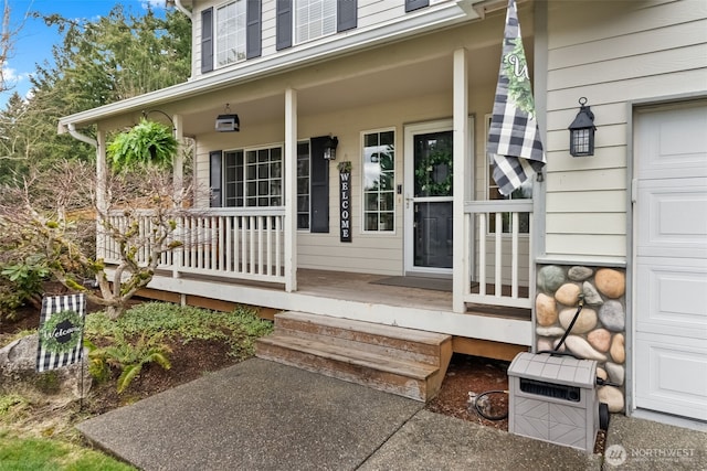 doorway to property with a garage and covered porch