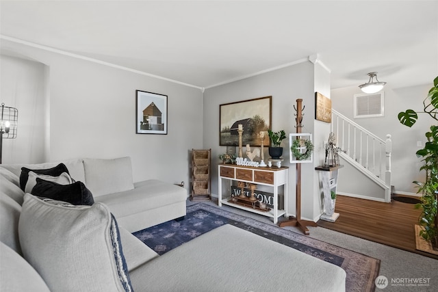 living room with baseboards, stairway, visible vents, and crown molding