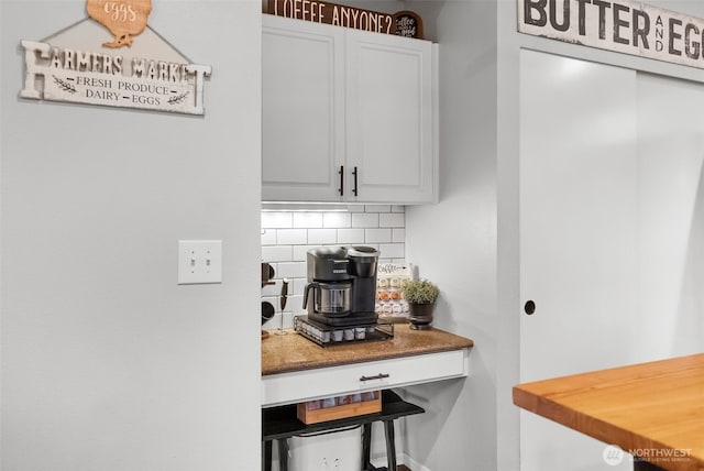 kitchen featuring tasteful backsplash and white cabinets