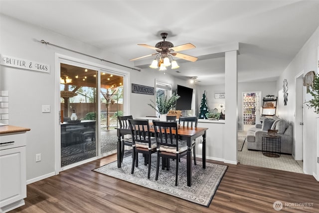 dining space with a ceiling fan, baseboards, and dark wood-style flooring