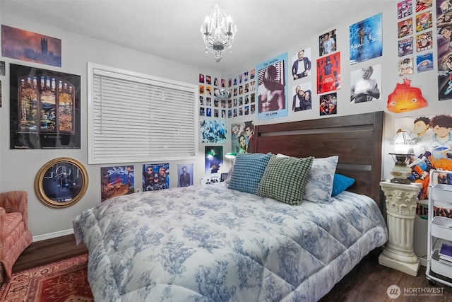 bedroom featuring baseboards, a chandelier, and wood finished floors