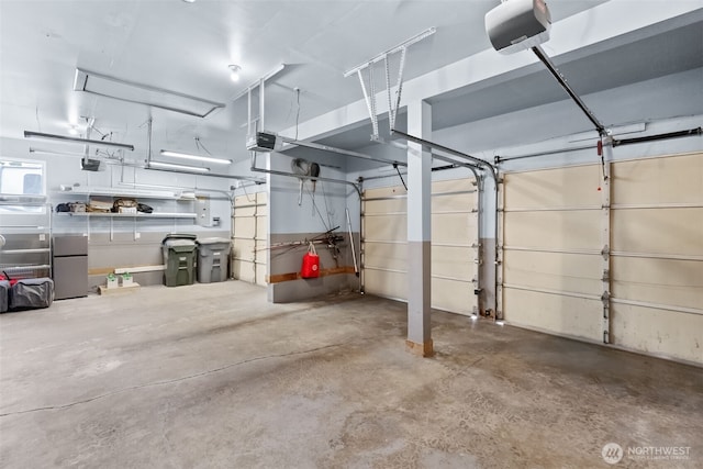 garage featuring a garage door opener and freestanding refrigerator