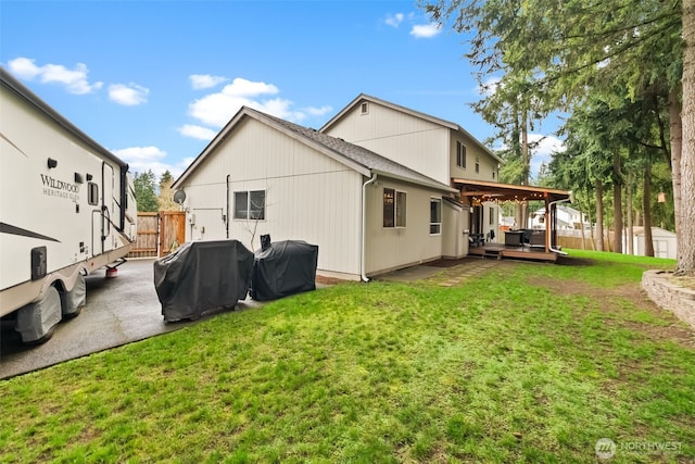 back of property with fence, a patio, and a yard