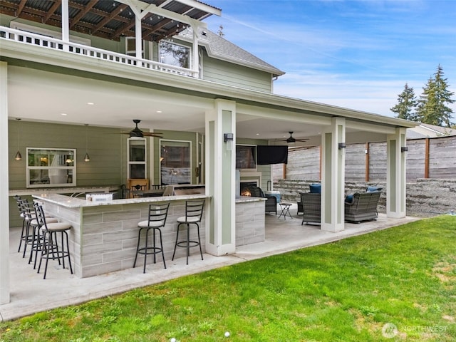 view of patio / terrace with outdoor lounge area, ceiling fan, a bar, and fence