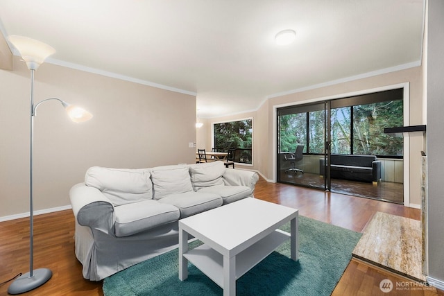 living area with ornamental molding, wood finished floors, and baseboards