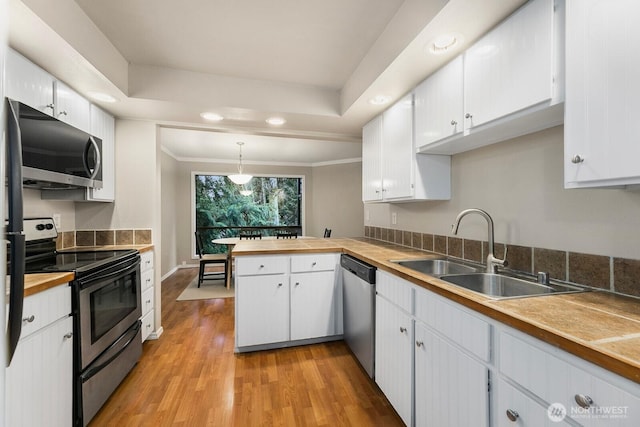 kitchen featuring appliances with stainless steel finishes, a sink, and white cabinets