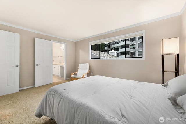 bedroom featuring ensuite bathroom, ornamental molding, baseboards, and light colored carpet