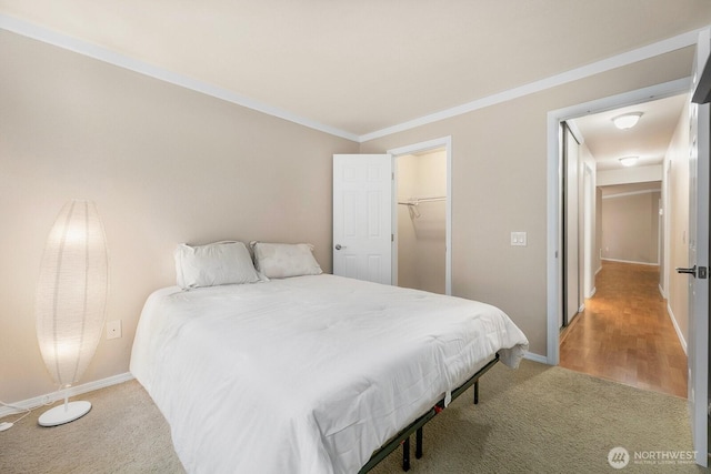 carpeted bedroom featuring ornamental molding and baseboards