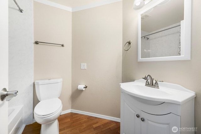 bathroom featuring visible vents, baseboards, toilet, wood finished floors, and vanity