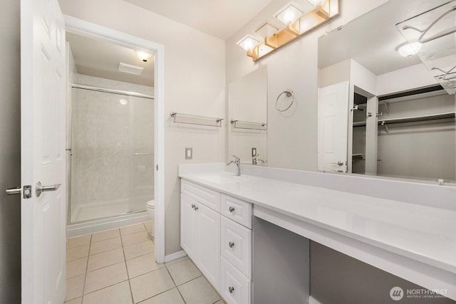 bathroom with toilet, a shower stall, vanity, and tile patterned floors