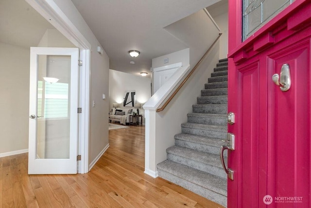 entryway featuring stairs, light wood-style floors, and baseboards