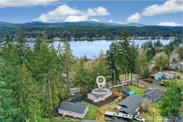 birds eye view of property with a water and mountain view and a view of trees