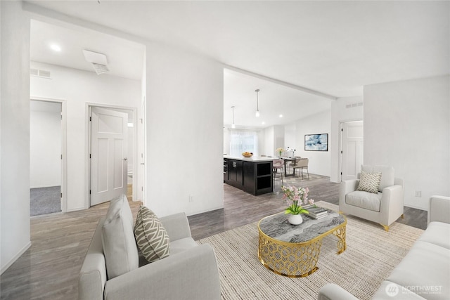 living room with visible vents, vaulted ceiling, wood finished floors, and recessed lighting