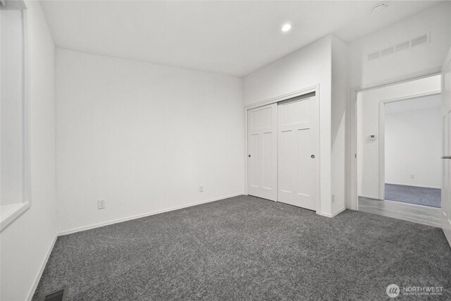 unfurnished bedroom with baseboards, dark colored carpet, visible vents, and recessed lighting