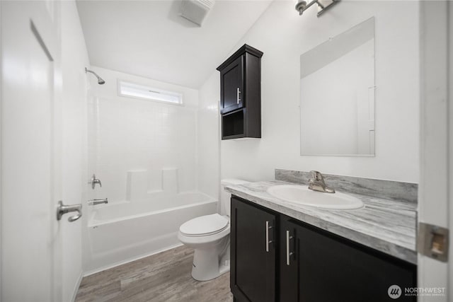 bathroom featuring toilet, shower / tub combination, wood finished floors, and vanity