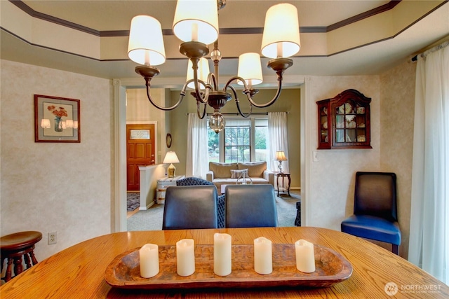 dining room with carpet floors, crown molding, and an inviting chandelier