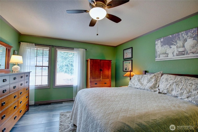 bedroom with ornamental molding, wood finished floors, a ceiling fan, and baseboards