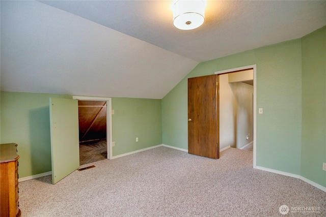 bonus room featuring lofted ceiling, carpet floors, and baseboards