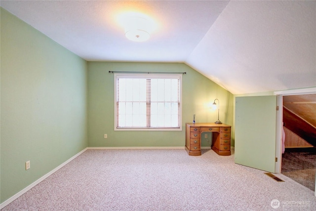 bonus room featuring lofted ceiling, carpet flooring, visible vents, and baseboards