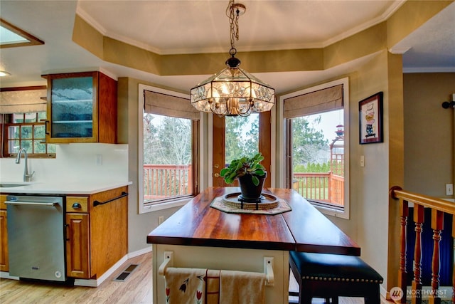 dining room with light wood-type flooring, baseboards, visible vents, and ornamental molding