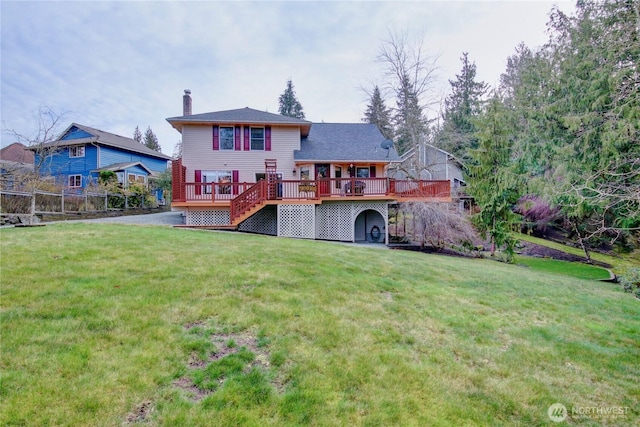 rear view of house featuring a lawn, a chimney, stairs, fence, and a deck