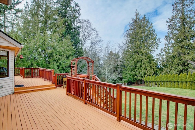 wooden deck featuring a lawn