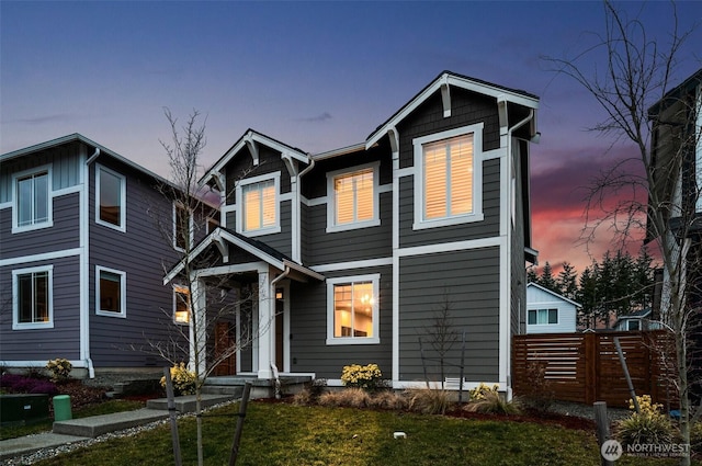 view of front of house with fence and a front lawn