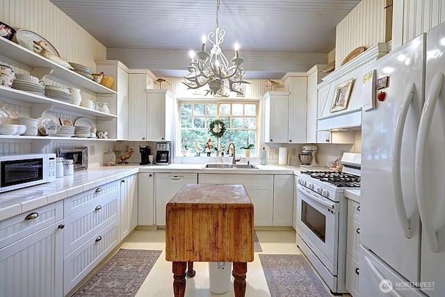 34800 J Pl, Ocean Park, WA 98640 - kitchen featuring decorative light fixtures, open shelves, light countertops, a sink, and white appliances