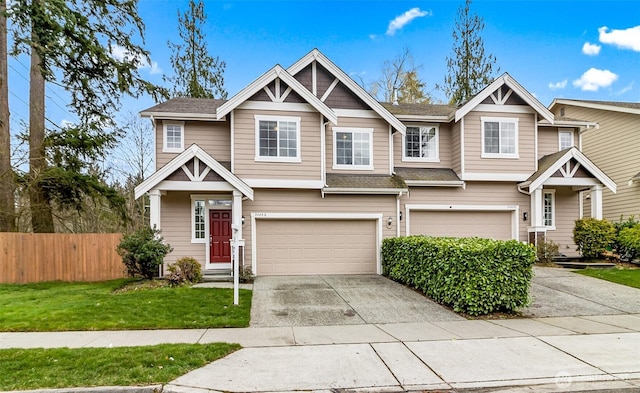 view of front of house with a front yard, fence, driveway, roof with shingles, and a garage