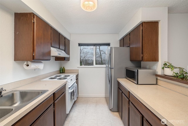 kitchen with under cabinet range hood, stainless steel microwave, light countertops, and electric stove