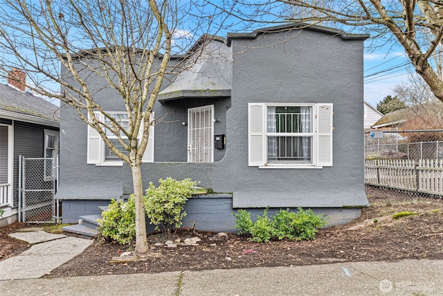 view of front of home featuring fence and stucco siding